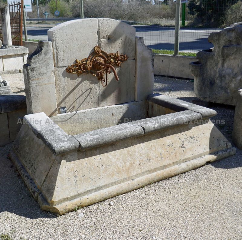 Antique stone fountain with cast-iron rosette and basin with splayed edges