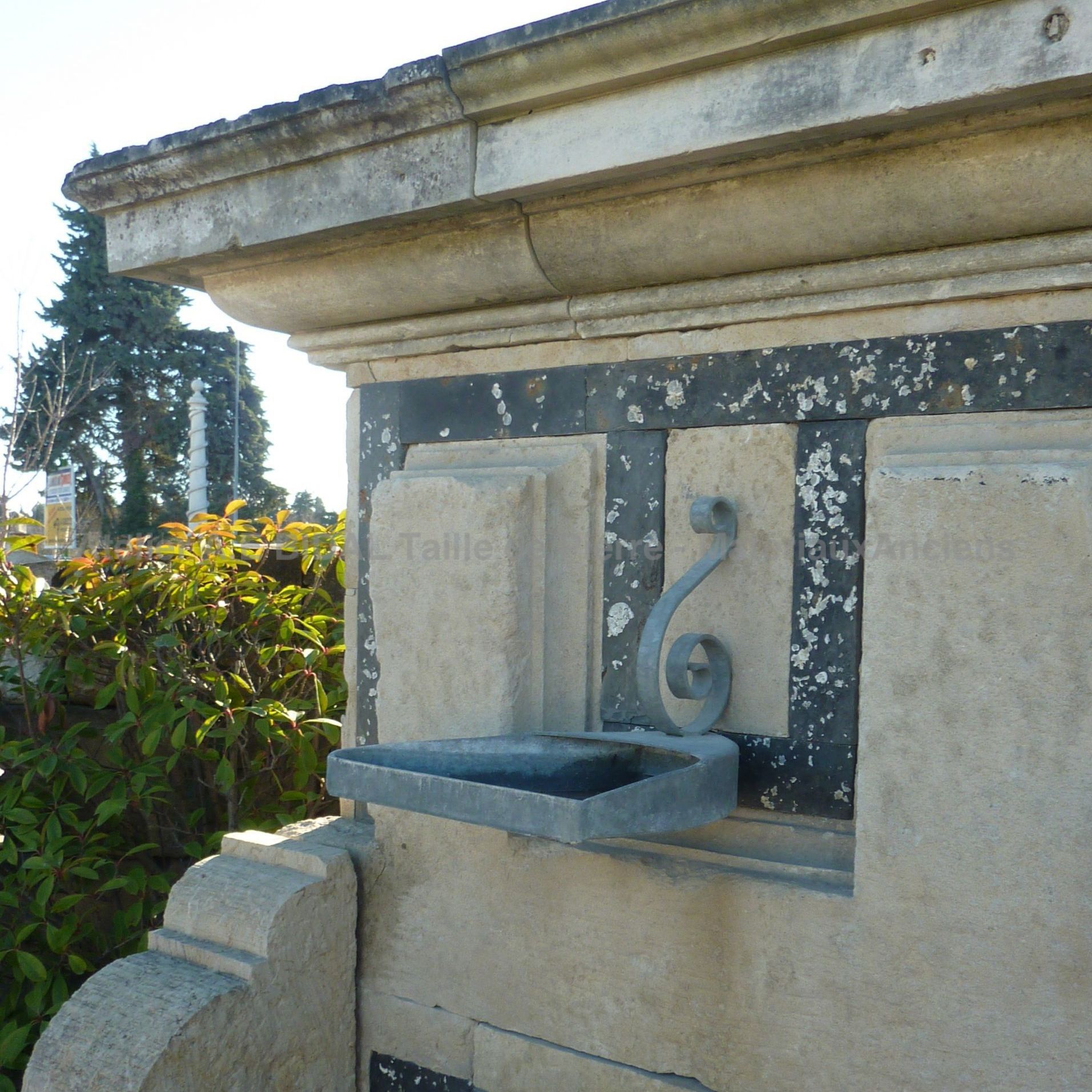 Grande fontaine en pierre avec sorties d'eau en métal | Fontaine d'extérieur avec bassin et fronton en pierres anciennes naturelles.