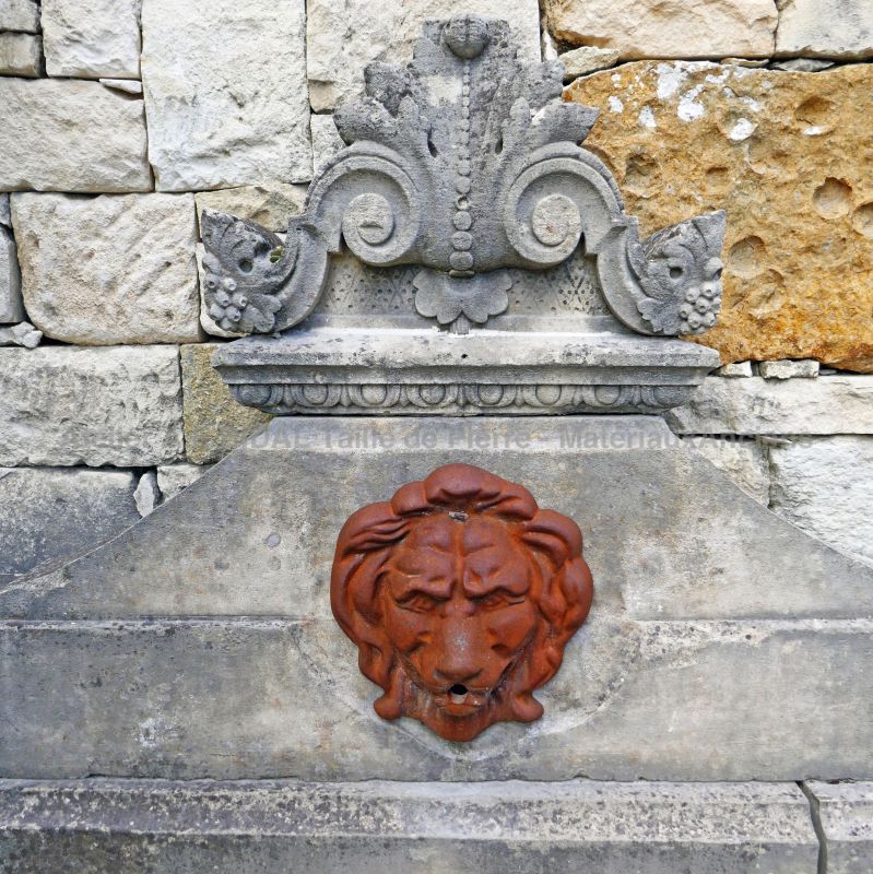 Detail of the cast iron lion head and finely hand-carved stone capital on our wall fountain of Provence.
