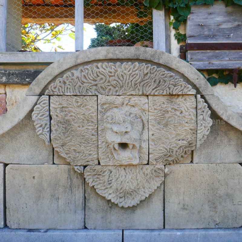Impressive hand-sculpted lion head hand-sculpted on the pediment of our stone wall fountain : Atelier Alain BIDAL (Provence)