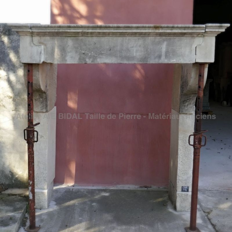 Haute cheminée ancienne en pierre de style Louis XIII