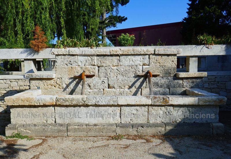 Old stone fountain in aged stones : large antique fountain for outdoor use.