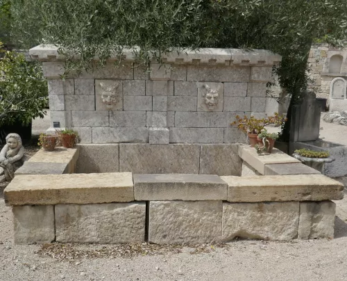 Grande fontaine en anciennes pierres | Fontaine de jardin avec bassin rectangulaire et élégant fronton à vendre en Provence chez le tailleur de pierre BIDAL.
