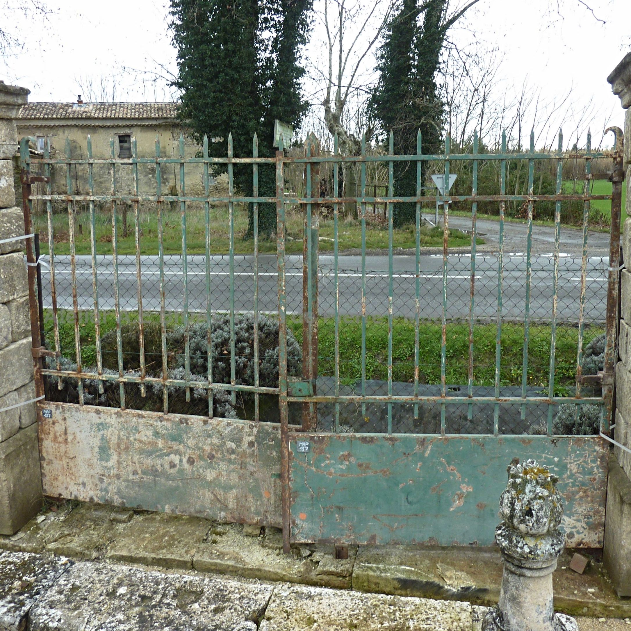 Portail en fer forgé un peu érodé par le temps - un portail ancien au style authentique de couleur verte.