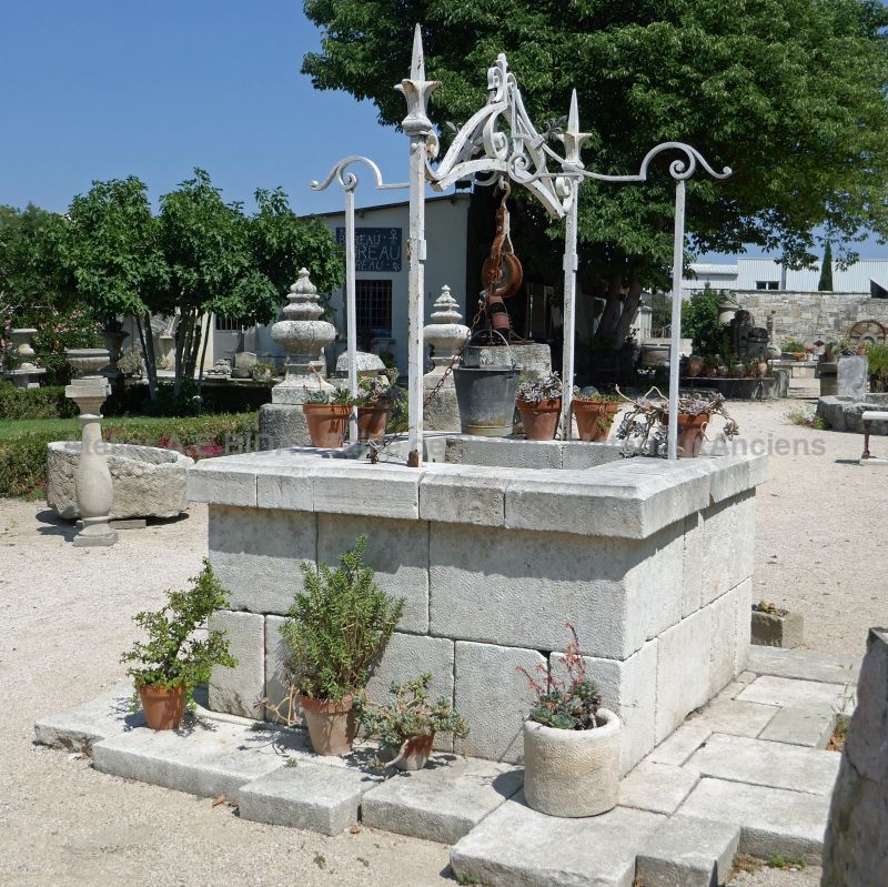 Ancient stone well with wrought iron top | Garden decoration by Atelier Alain Bidal in Provence