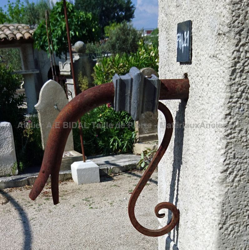 Détail de la belle ferronnerie ancienne qui sert de repose seau sur notre fontaine murale en vieilles pierres - Atelier Alain BIDAL.