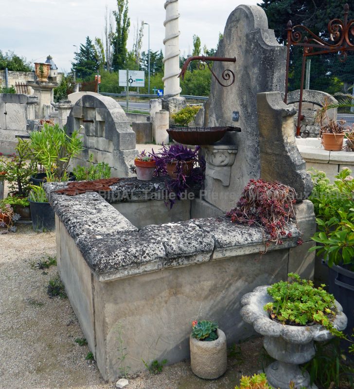 Patinated stone wall fountain | Garden fountain with basin and pediment in reclaimed elements.
