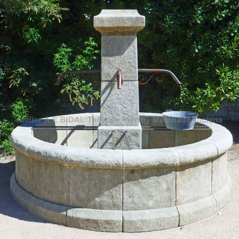 Round central fountain in weathered natural stone : Atelier Alain BIDAL (Provence)