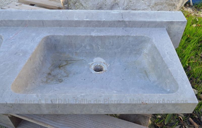 Détail de la vasque sur notre long évier ancien à double vasques en pierre marbrière.