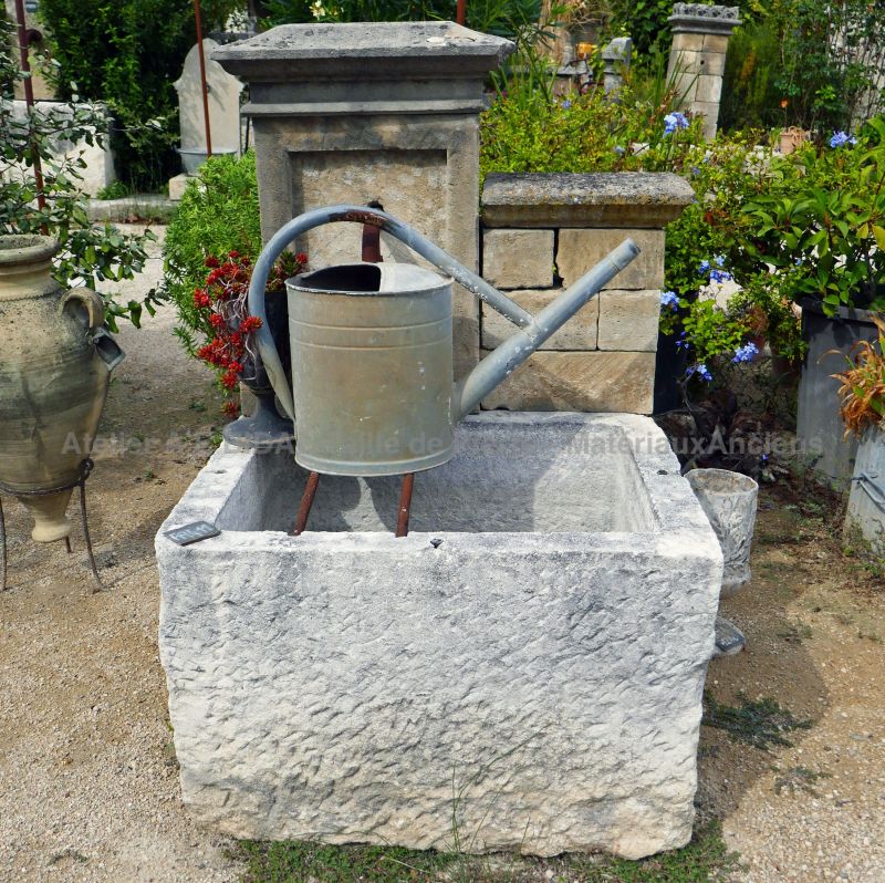 Small wall fountain in stone | Outdoor fountain with a massive stone trough.