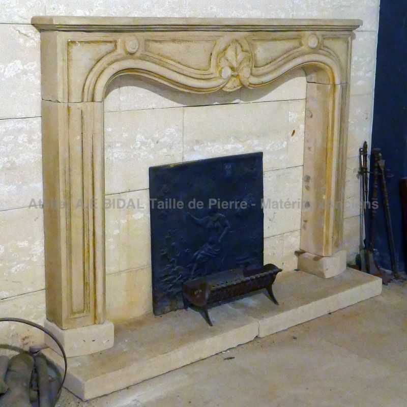 Antique veneering fireplace in patinated stone with base : Atelier Alain BIDAL, Provence
