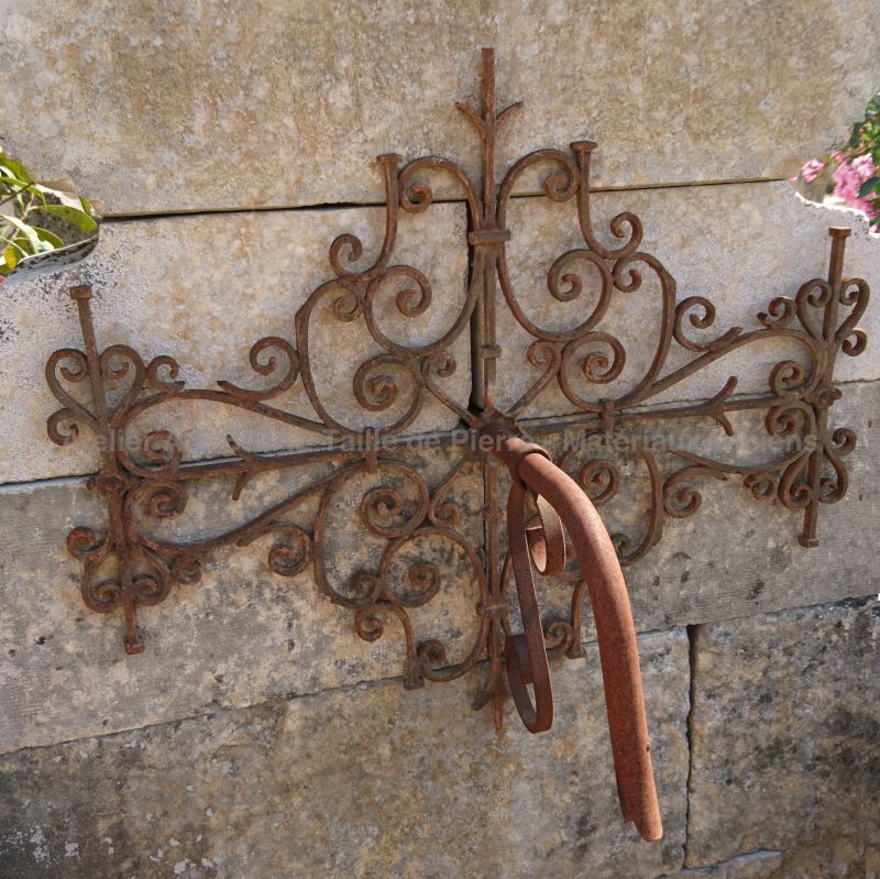 Detail of the water outlet decorated with forged scrolls on our stone garden fountain.