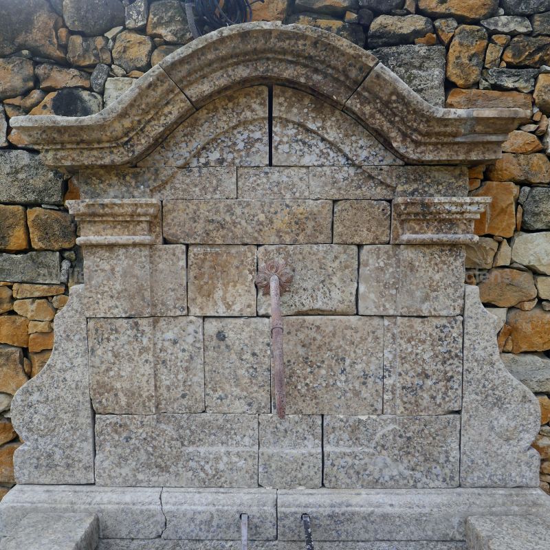 Fronton avec ancienne sortie d'eau en fer forgé sur notre fontaine murale en pierre : Atelier Alain BIDAL