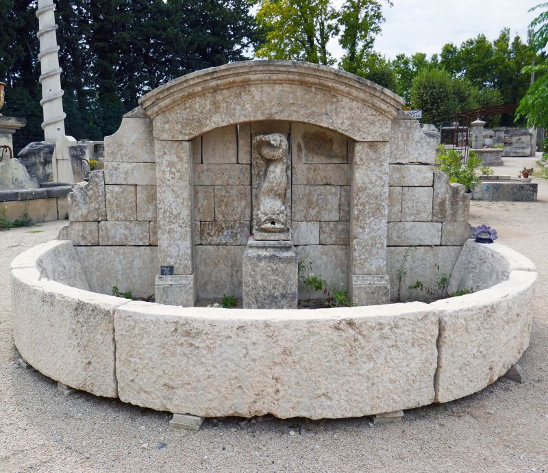 Large fountain in old stones for outdoor landscaping | Fountain with fish spitting water carved in stone.