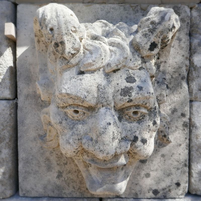 Detail of the stone carved water outlet on the pediment of this large wall fountain designed entirely in Isle sur la Sorgue.