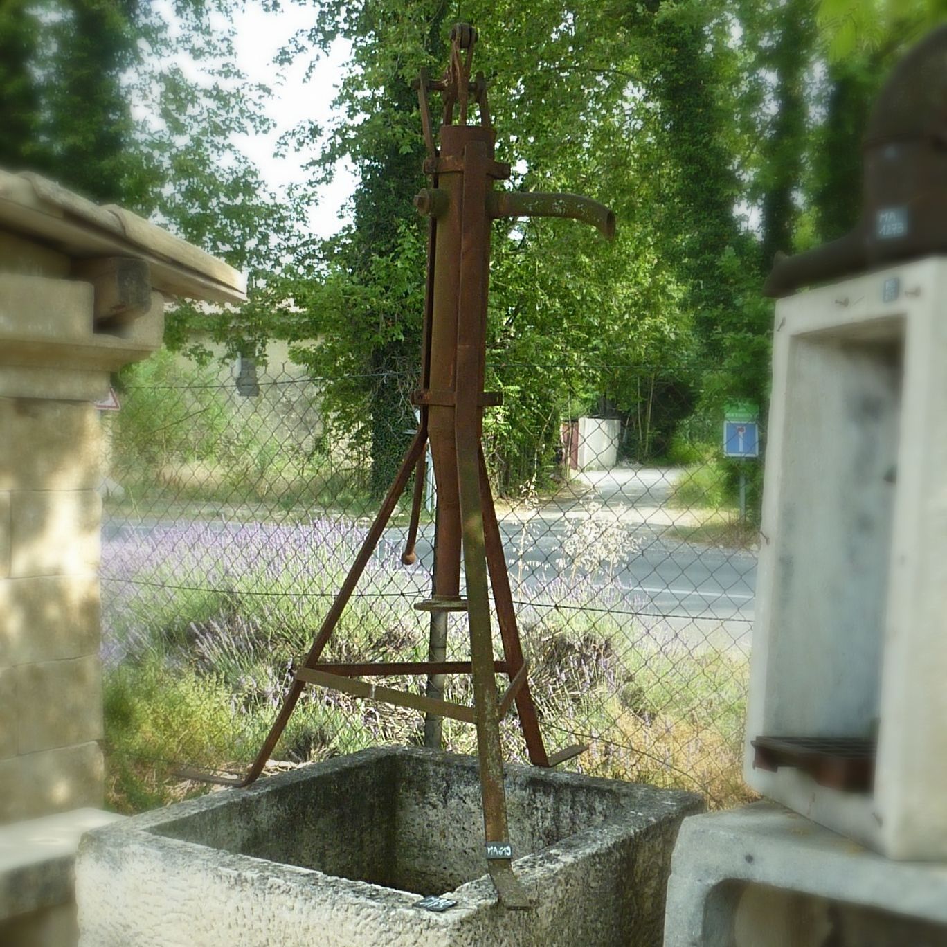 Une pompe manuelle en fonte ancienne sur socles- ancienne pompe à eau.