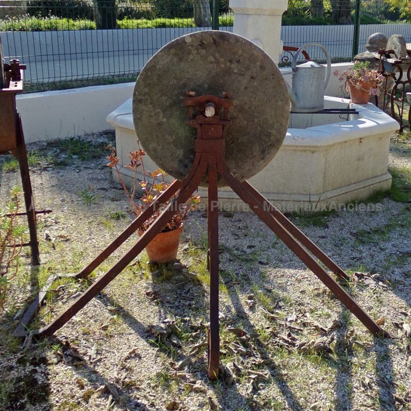 Meule ancienne en pierre sur pied massif en fer forgé par les Matériaux Anciens en Provence Alain BIDAL