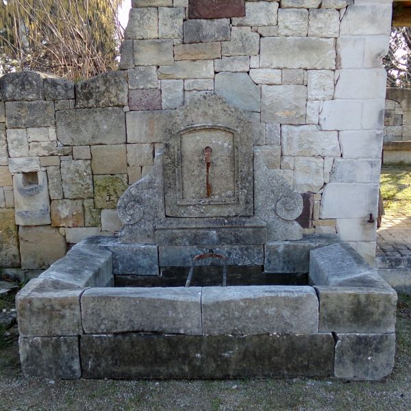 Fontaine ancienne en pierres patinées : une fontaine murale en pierre de chez l'Atelier Alain BIDAL (Provence)