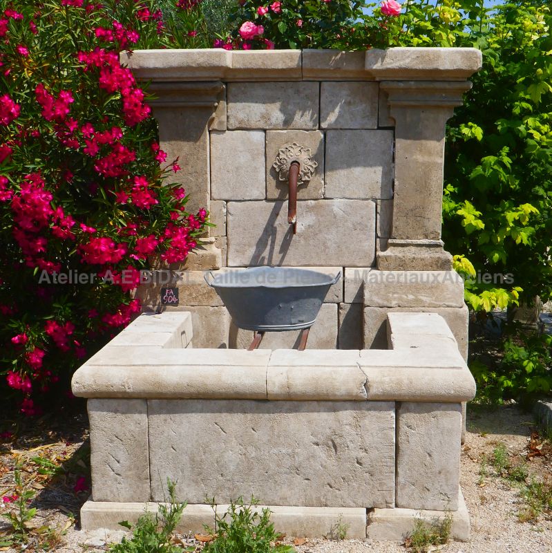 Fontaine de jardin avec fronton travaillé doté de 2 colonnes et d'une rosace en pierre : Atelier Alain BIDAL, Provence