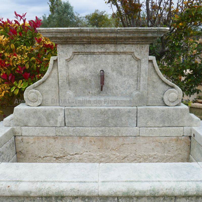 Weathered-by time natural stone wall fountain for a zen, chic or authentic garden