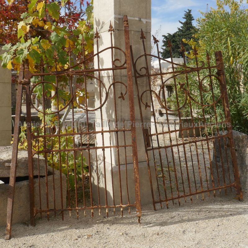 Magnificent old two-doors gate in riveted wrought iron very nicely forged decors.