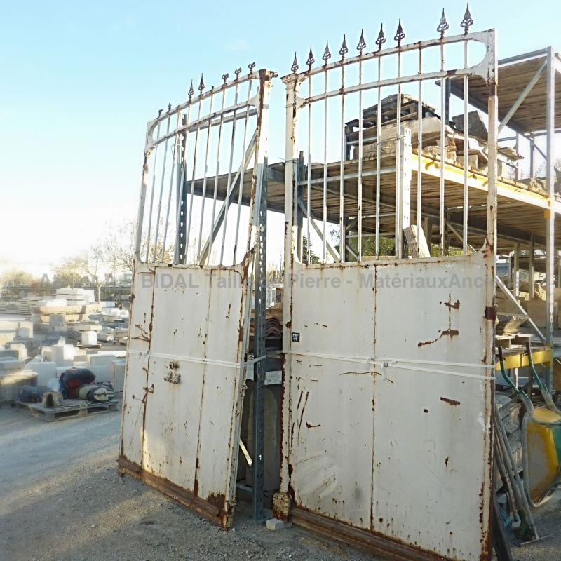 Portail ancien en fer forgé patiné de rouille avec un portillon ancien pour passage piéton.