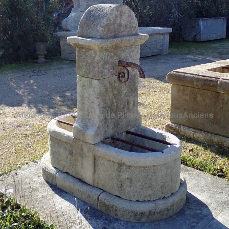 Fontaine en pierres patinées avec double bac massif et étroit fronton : Atelier Alain BIDAL, Provence