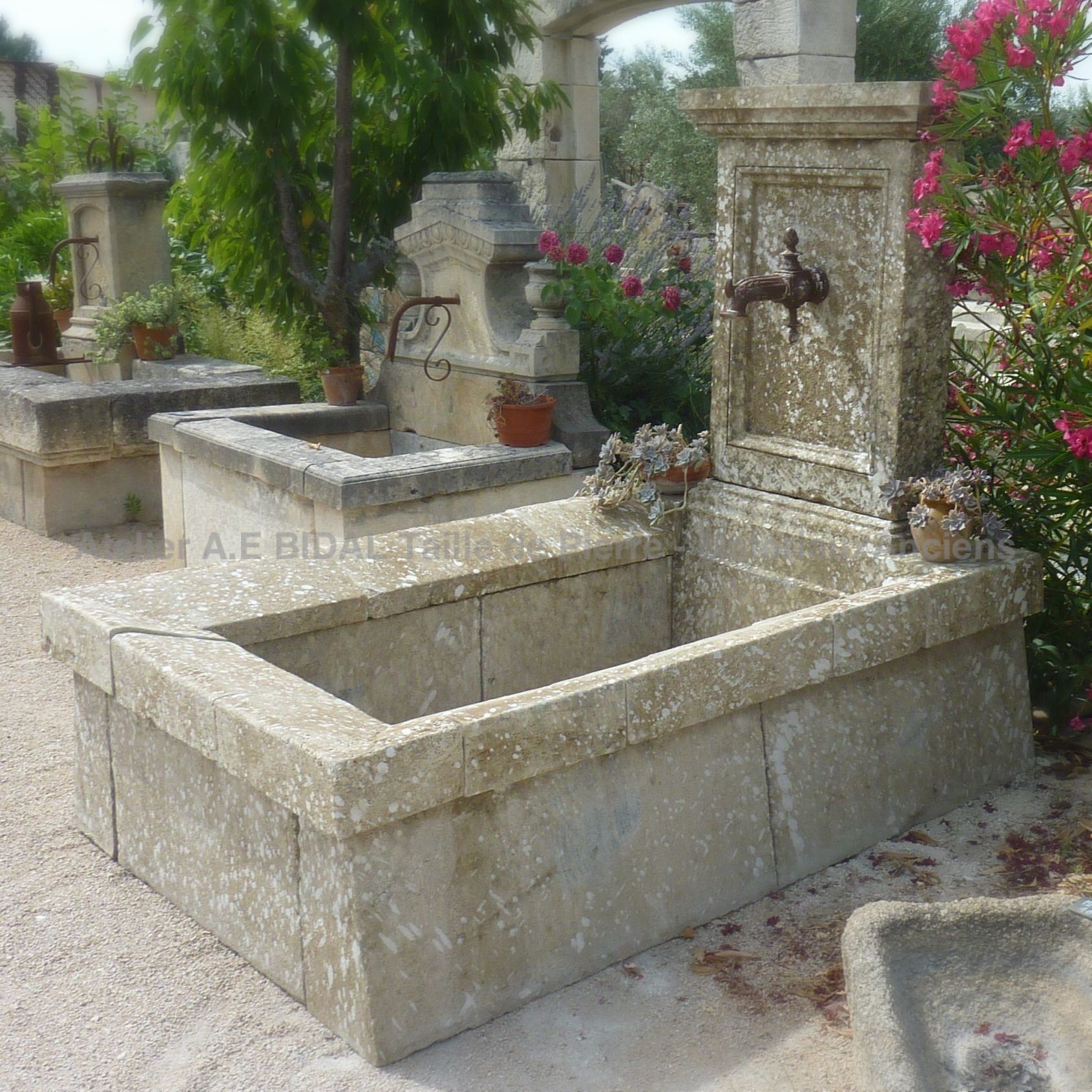 Large stone wall fountain : an outdoor fountain with wash-house-like basin in ancient stones.