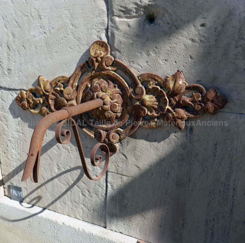 Antique stone fountain with cast-iron rosette and basin with splayed edges