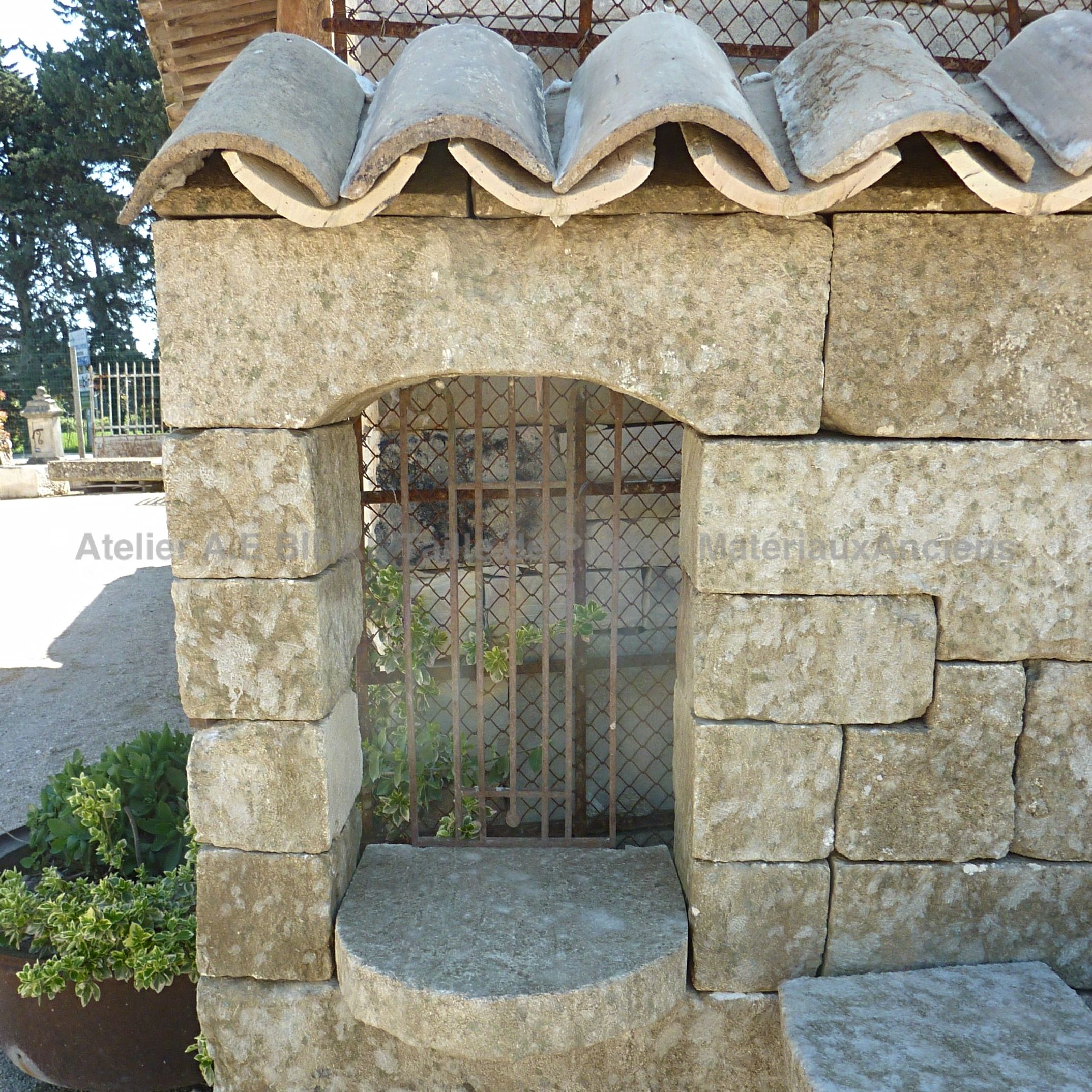 Grille en fer forgé ancien sur notre fontaine murale avec toit | Une fontaine en vente chez Alain BIDAL en Provence.