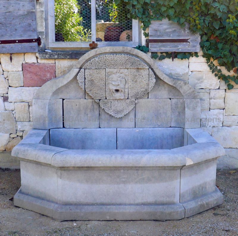 Garden fountain in carved weathered limestone - Natural stone wall fountain for sale at Atelier Alain BIDAL (Provence)
