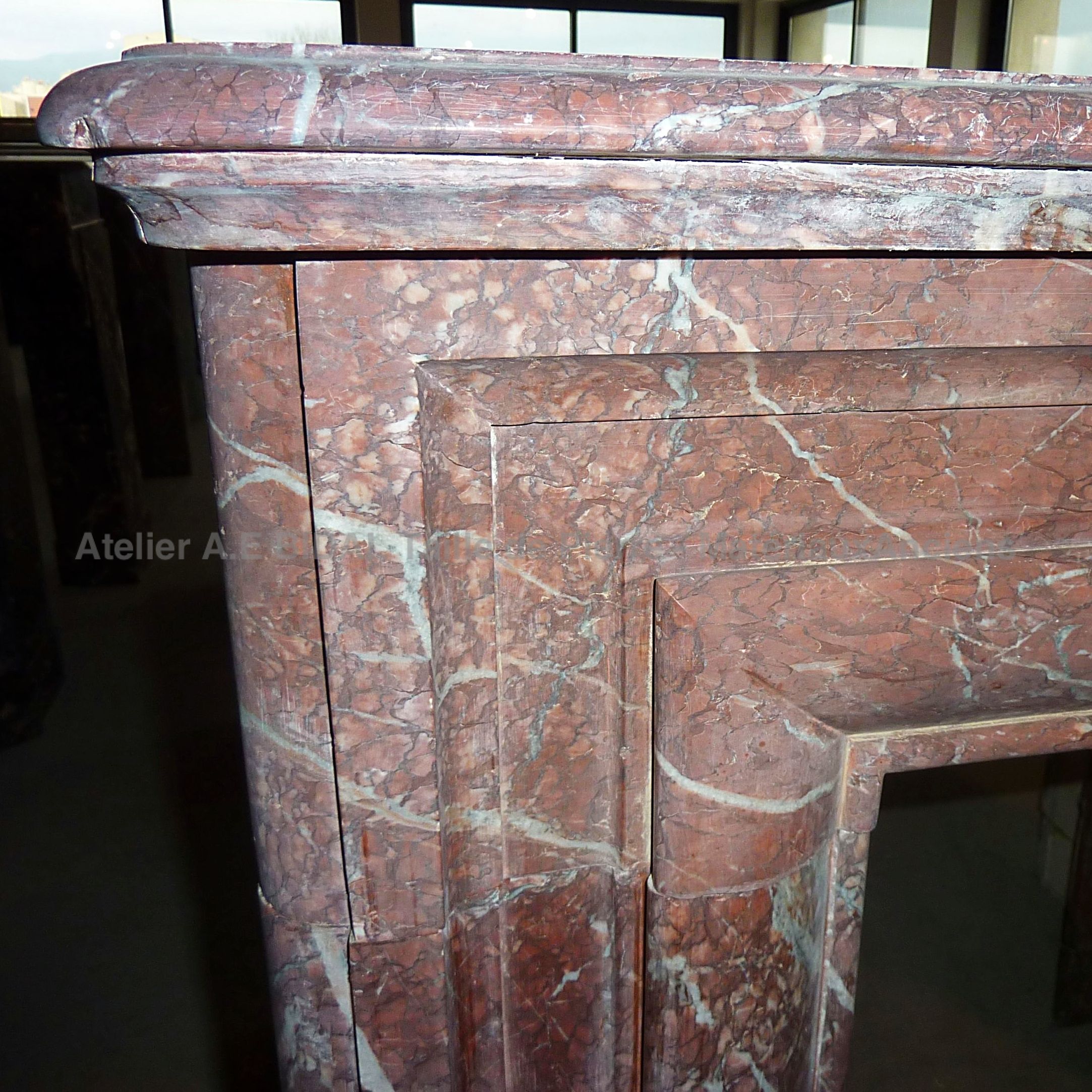 Cheminée marbre rouge en gros plan - cheminée ancienne avec de belles veinures blanches dans le marbre.