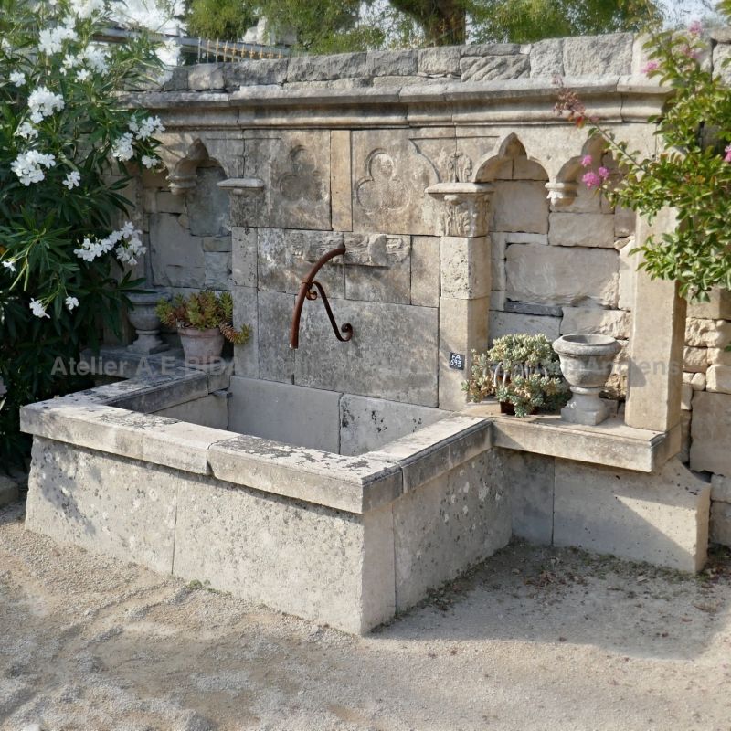 Wall fountain with a gothic stylem  made of authentic traditional materials - stone fountain with large pediment.
