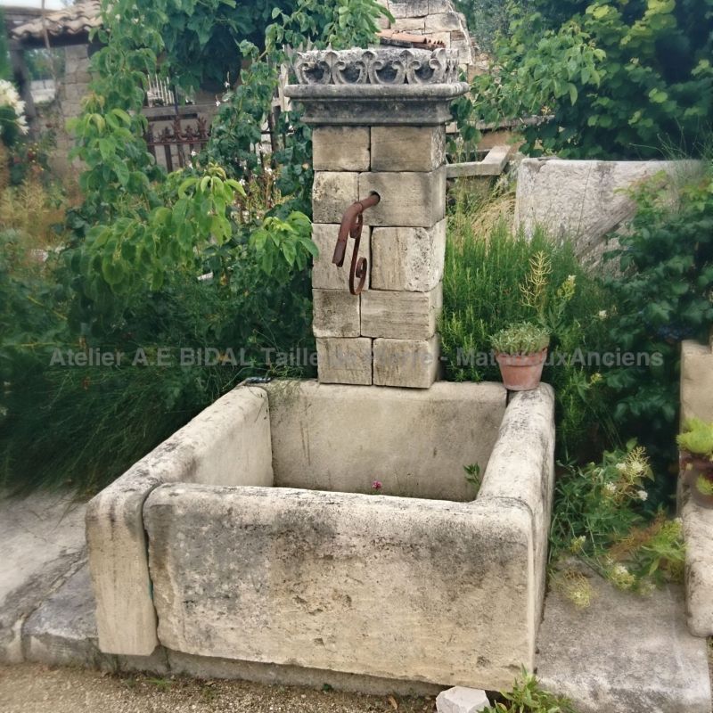 Stone fountain designed to be placed against a wall in a garden | Garden fountain with pediment and basin.