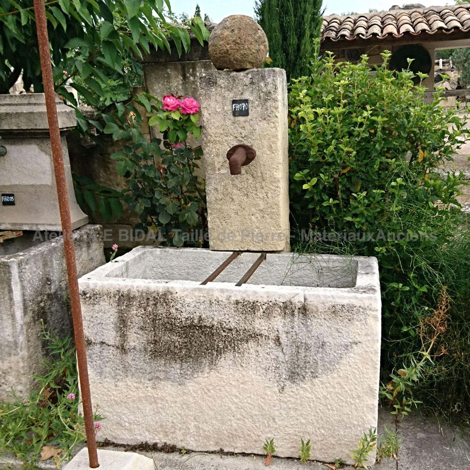 Fontaine de jardin ancienne en pierre avec bac ancien en vente chez Alain Bidal, tailleur de pierre en Provence.