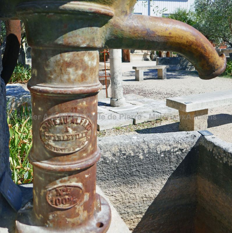 Détail de l'ancienne pompe manuelle en fonte sur notre fontaine de jardin.