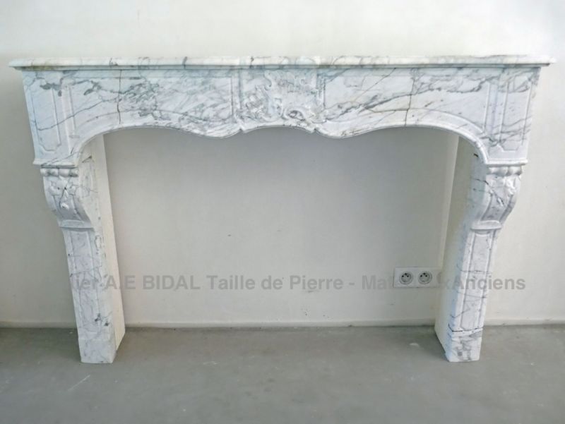 Fireplace in white marble and nicely carved and decorated - old fireplace with an elegant look.