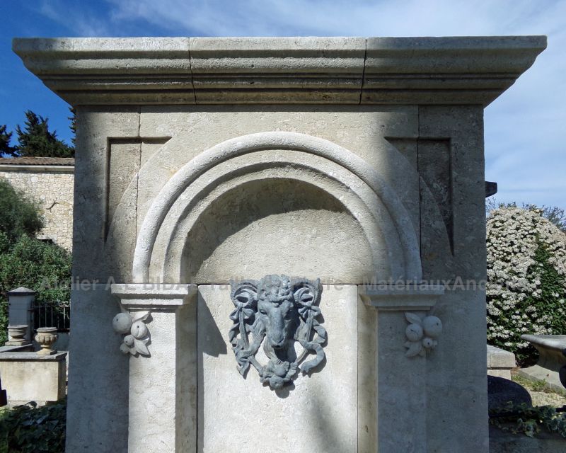 Élégante fontaine murale en pierre patinée avec tête de bélier en plomb - Atelier Alain BIDAL (Provence)