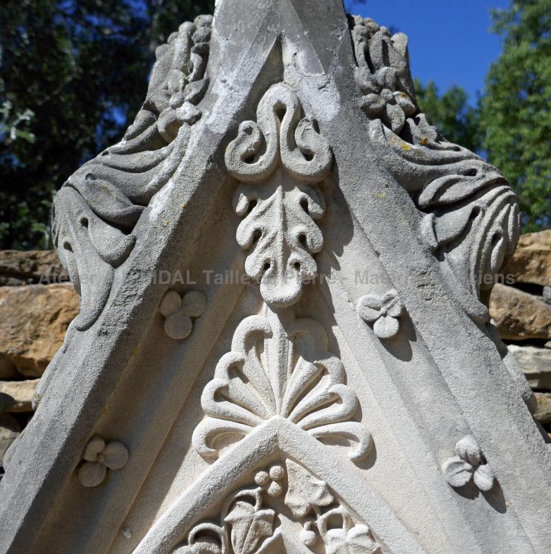 Détails des sculptures réalisées à la main sur cette ancienne stèle en pierre de Savonnière patinée.