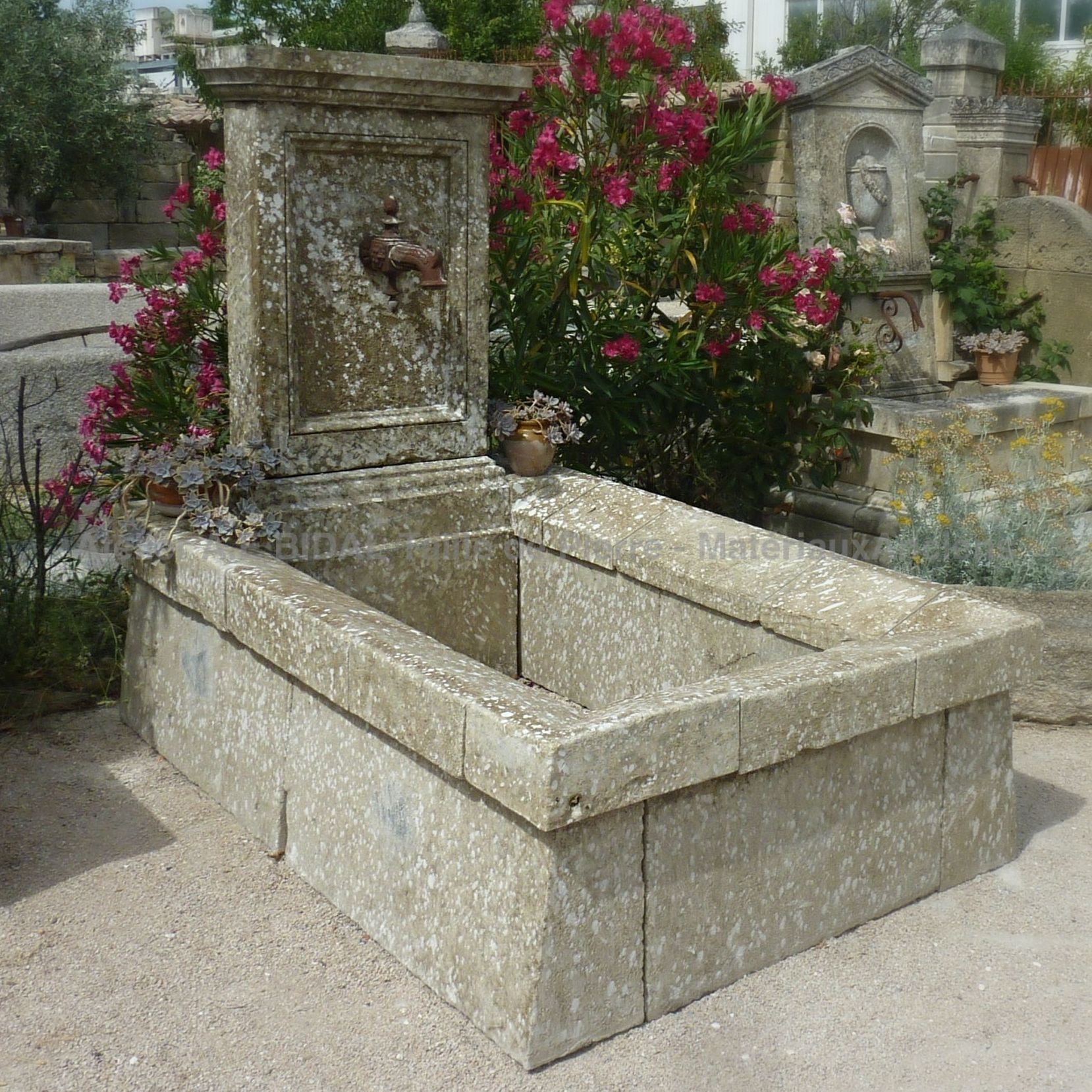 Long water fountain in ancient stones for a garden full of charm !