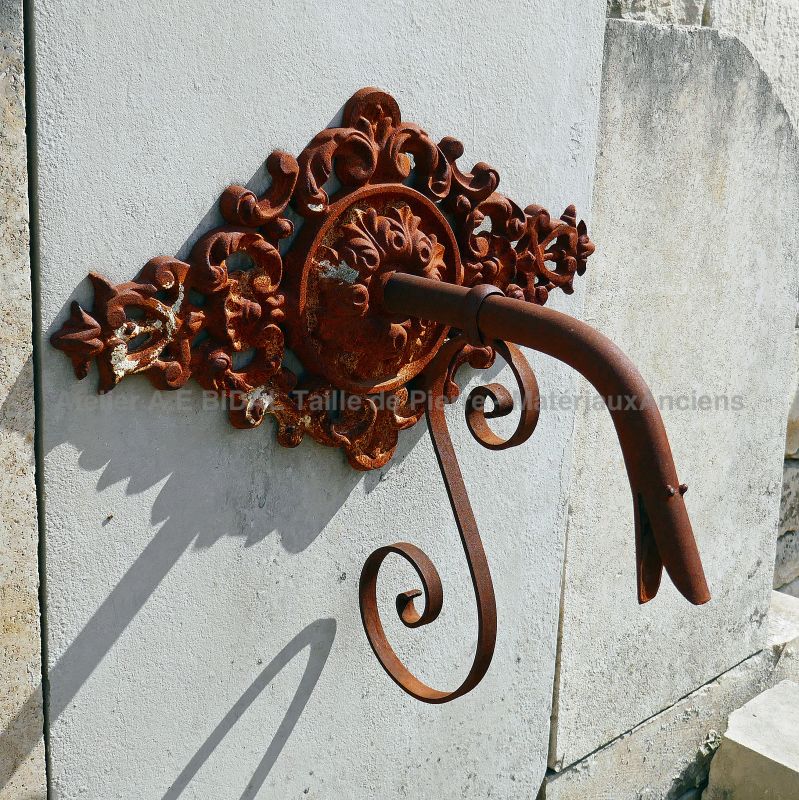 Detail of the beautiful iron palmette on our wall fountain in ancient stones for sale in Provence.