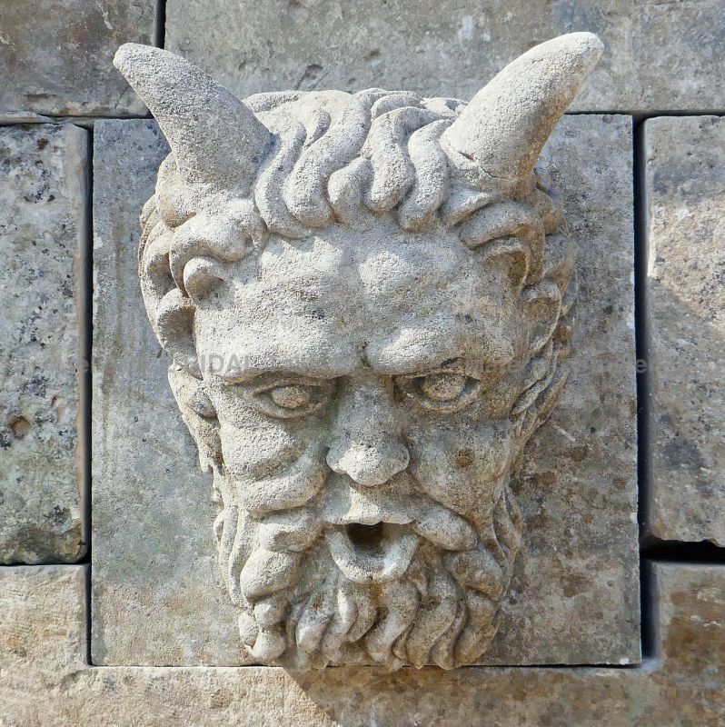 Detail of the hand-sculpted head as water outlet on the pediment of our large stone fountain