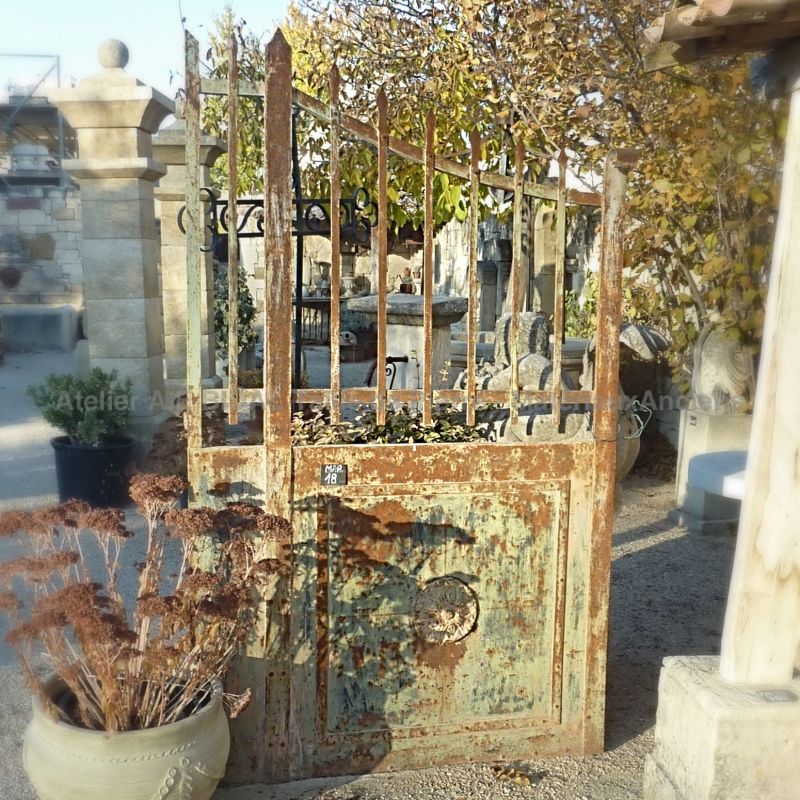 Portail ancien en fer forgé de charme rural avec des dormants.